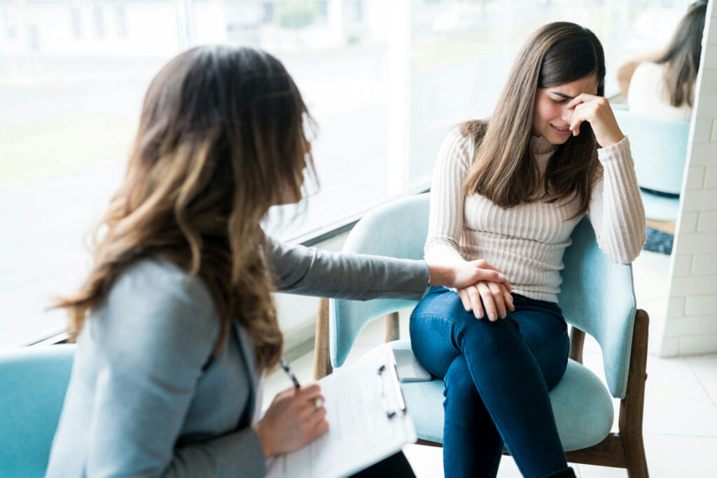 therapist discussing the stages of relapse with her patient during an emotional moment